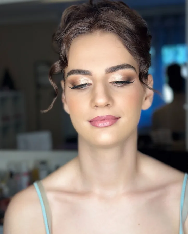 Djevojka našminkana za svečanost s kosom u punđi.