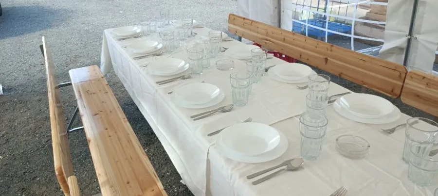 Posložen stol za blagovanje s drvenim klupama.