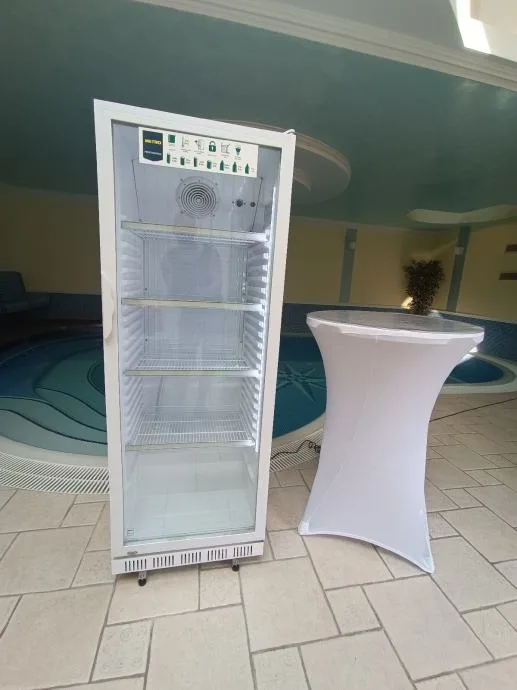 Barski stol bijele boje i hladnjak.