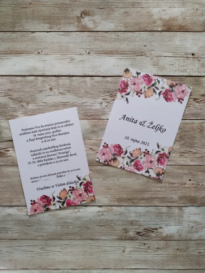 Pozivnica za vjenčanje s raznim ružičastim cvijećem, imenima mladenaca u sredini i datumom vjenčanja.