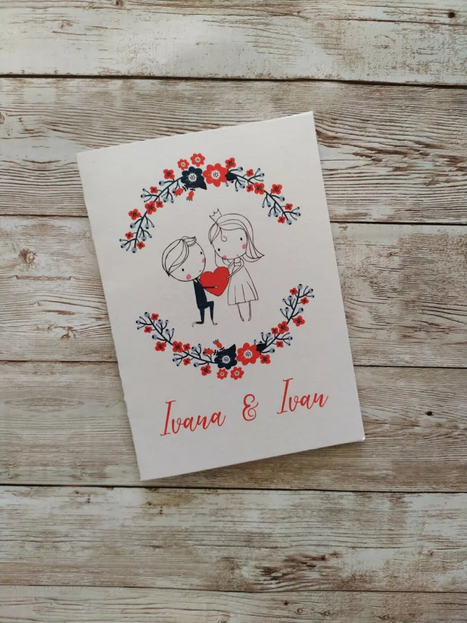 Pozivnica za vjenčanja simenima, i ilustracijom mladoženje koji daje srce mladoj, okruženi cvijećem.