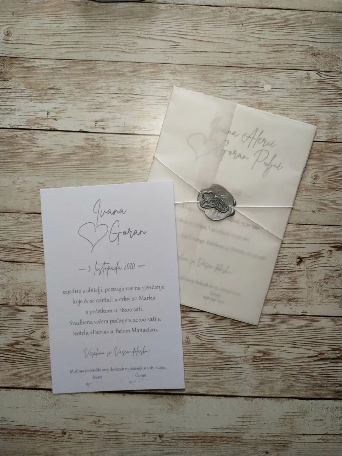 Pozivnica za vjenčanje brenda Papirusha na bijelom papiru, s omotom zamagljenim i srebrenim pečatom.