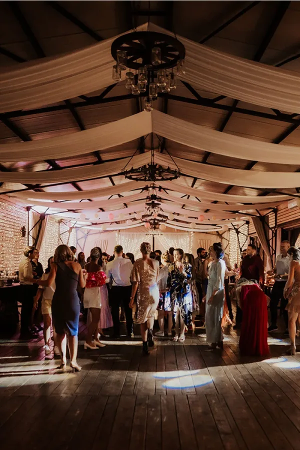 Gosti na vjenčanju plešu na podiju sale.