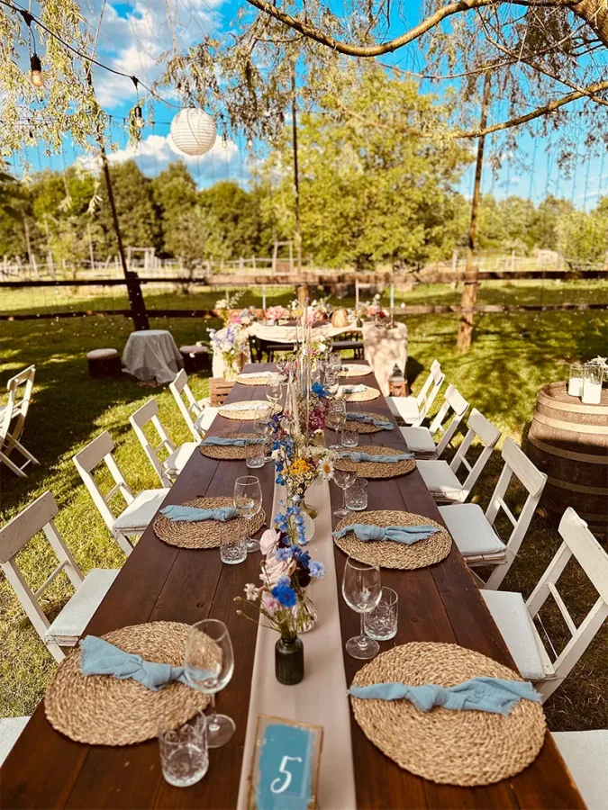 Pogled na drveni stol za vjenčanje u prirodi na Ranch Kurilovec.