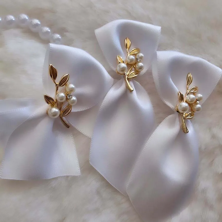 Bijeli rever za vjenčanje s zlatnom grančicom i biserima.