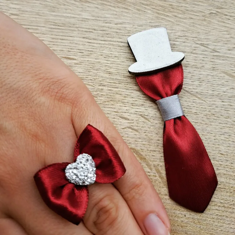 Prsten s crvenom mašnom i crveni rever s kapicom.