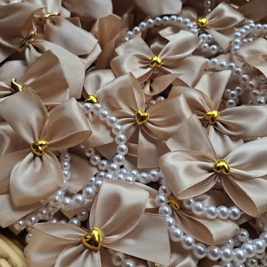 Svijetlo smeđe mašne na bisernim narukvicama.