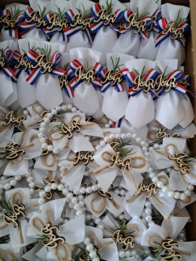 Bijeli reveri s Hrvatskom zastavom i bijele mašne na bisernim ogrlicama s natpisom J&R.