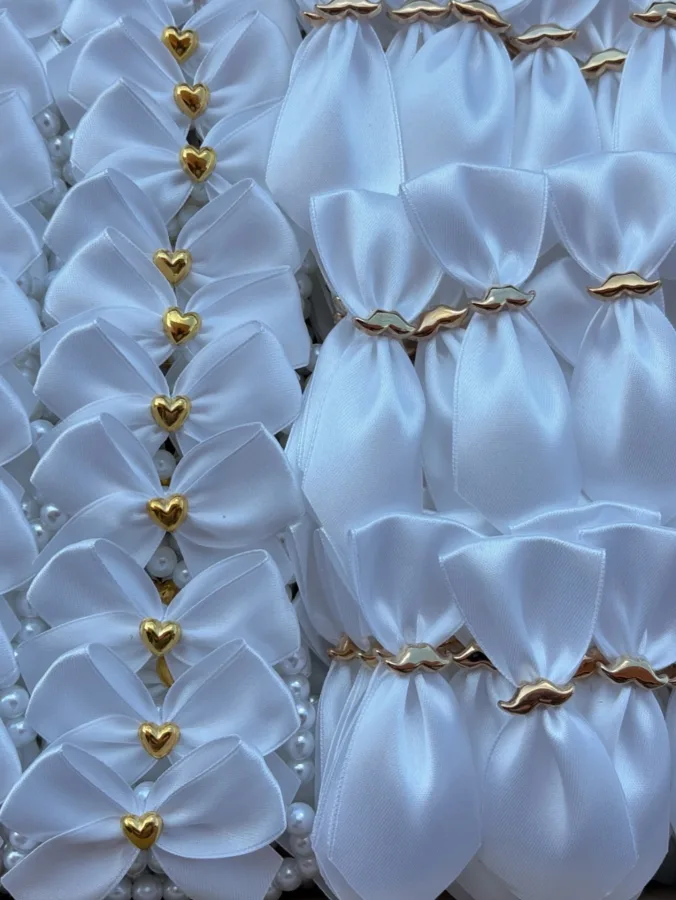 Bijeli reveri i narukvice za vjenčanje sa zlatnim akcentima.