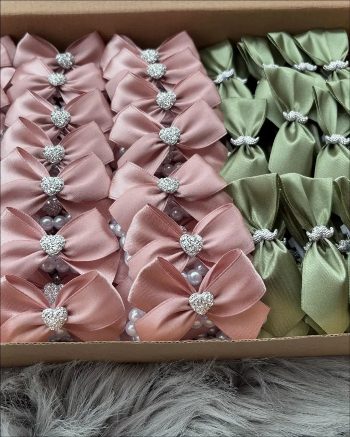 Roze mašne sa srebrnim srcima i maslinasto zeleni reveri sa srebrnim brkovima.