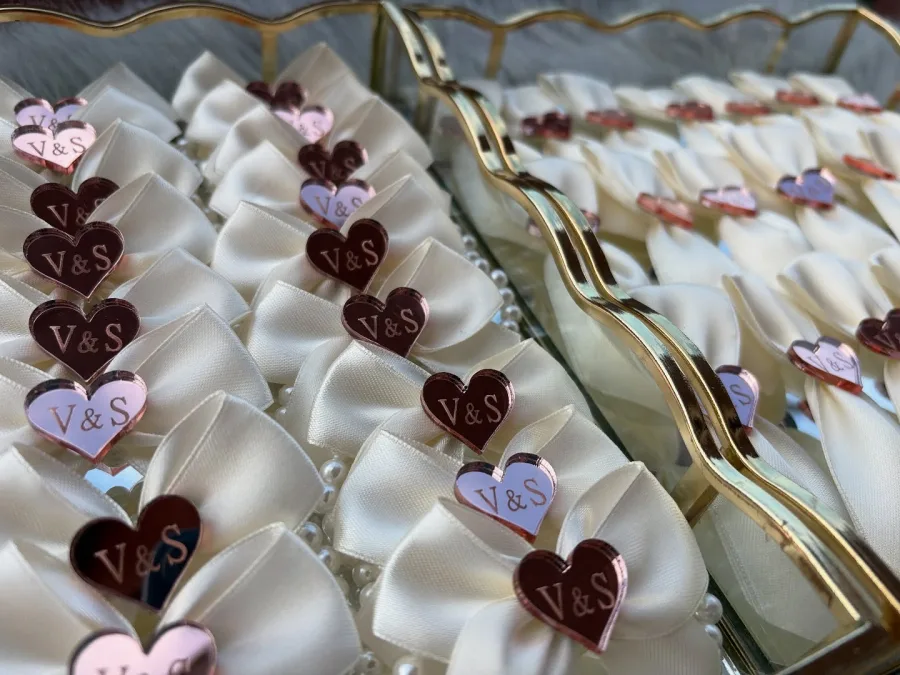 Bijeli reveri za vjenčanje sa rozim srcem i natpisom "V&S"