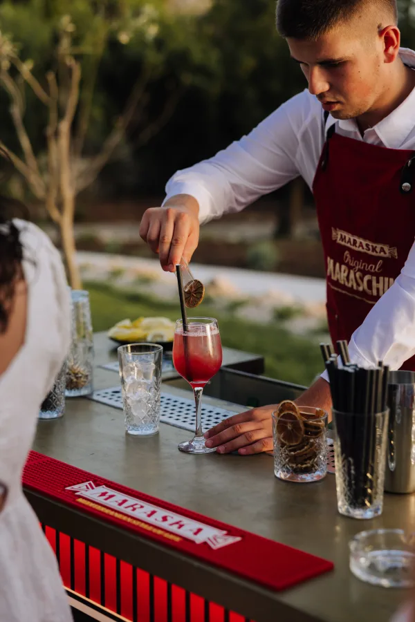 Koktel majstor radi crveni koktel na šanku na vjenčanju Heritage event venue .