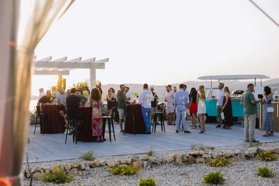 Svećano obućeni uzvanici vjenčanja na terasi s pogledom na more u blizini Dubrovnika.