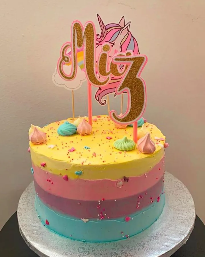 Torta u duginim bojama i jednorogom za rođendan.