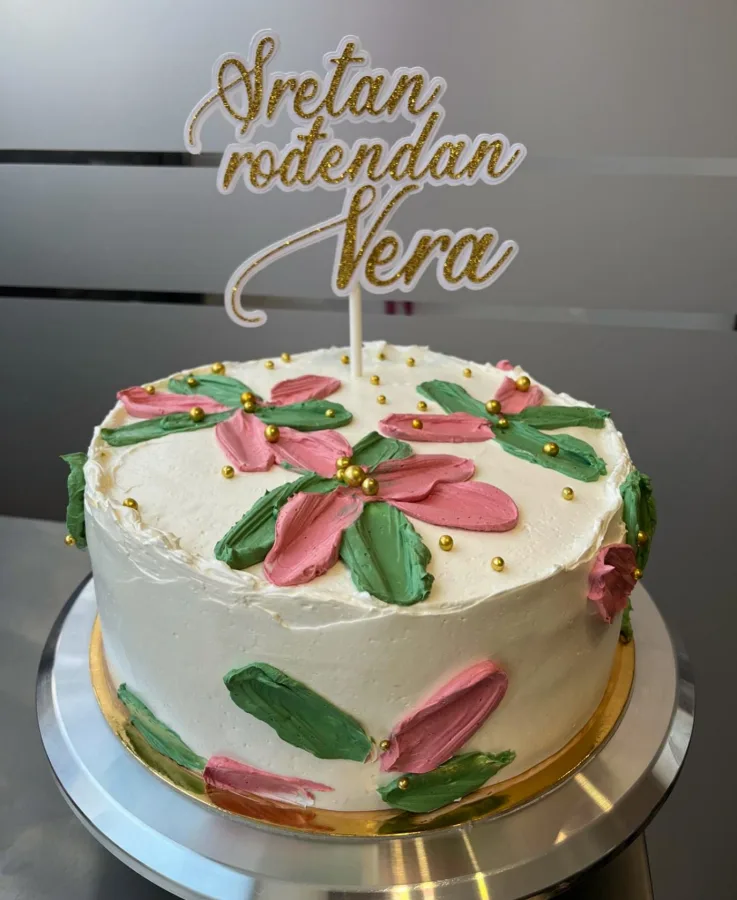 Bijela torta s pastelinm cvjetovima i natpisom Sretan Rođendan Vera.