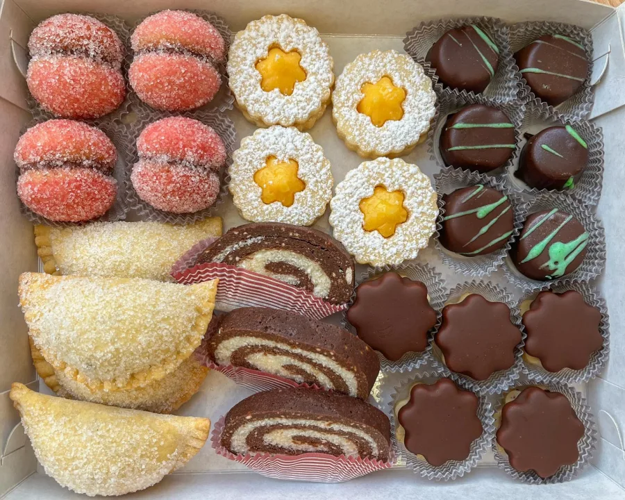 Kutija puna suhih kolača - rolada, breskvica, linzera, čokoladnih bombica.