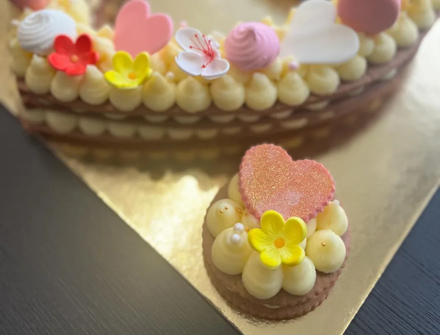 Torta s žutom kremom, rozim srcem i žutim cvjetićem.