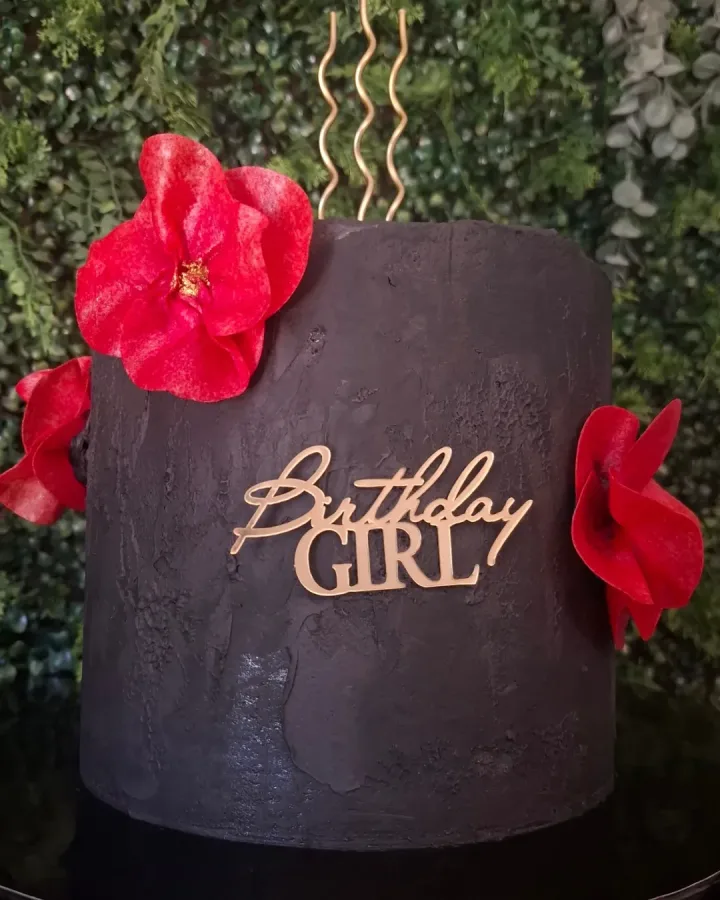 Smeđa torta s crvenim cvijećem i natpisom "Birthday girl".