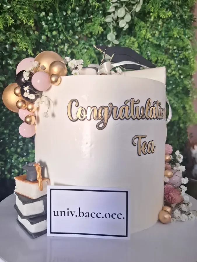 Torta povodom diplome bakalara ekonomije uređena figurama knjiga i kape od fakulteta od fondanta s natpisom na engleskom "Congratulations Tea".