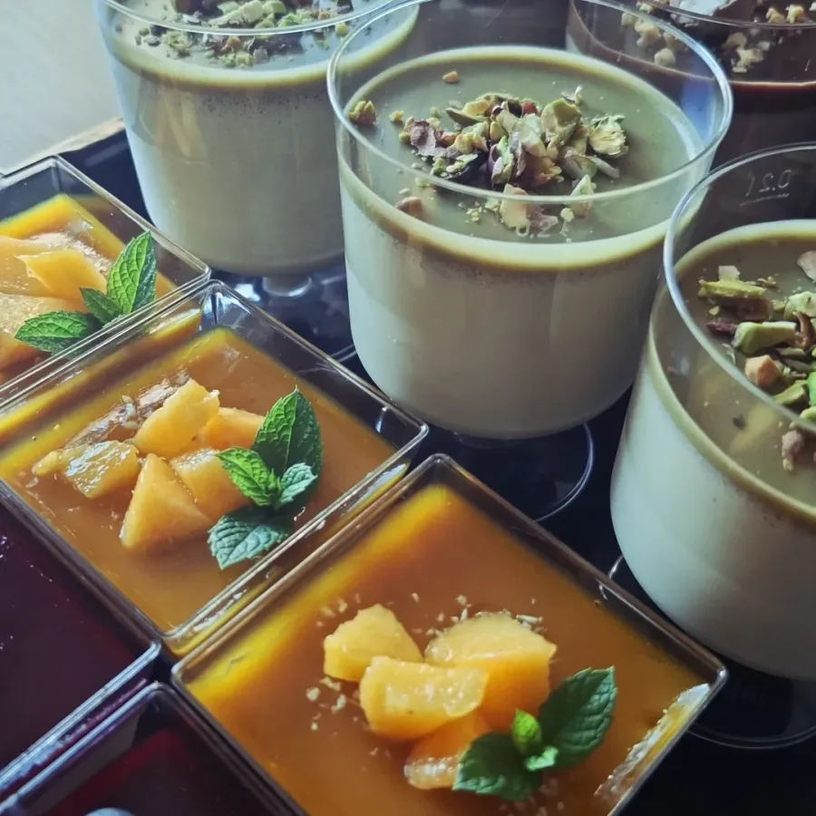 Panna cotta u čašicama s preljevima od manga i pistacije.
