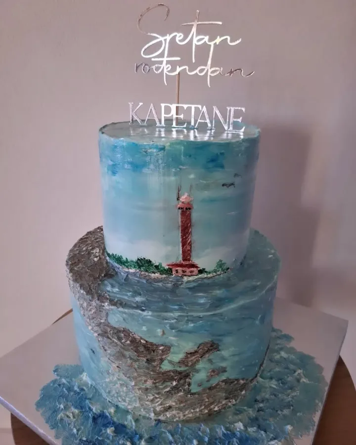 Torta na dva kata koja prikazuje more i scvjetionik na otočiću te natpisom "Sretan rođendan kapetane".