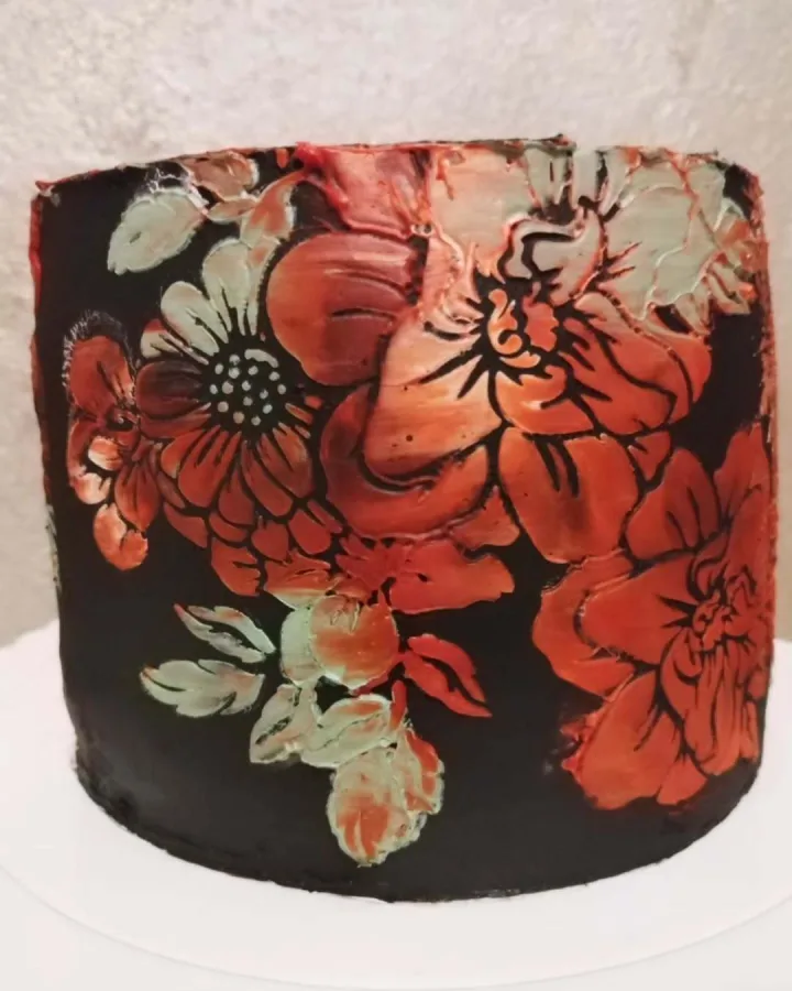 Smeđa torta s crveno bijelim cvijećem.