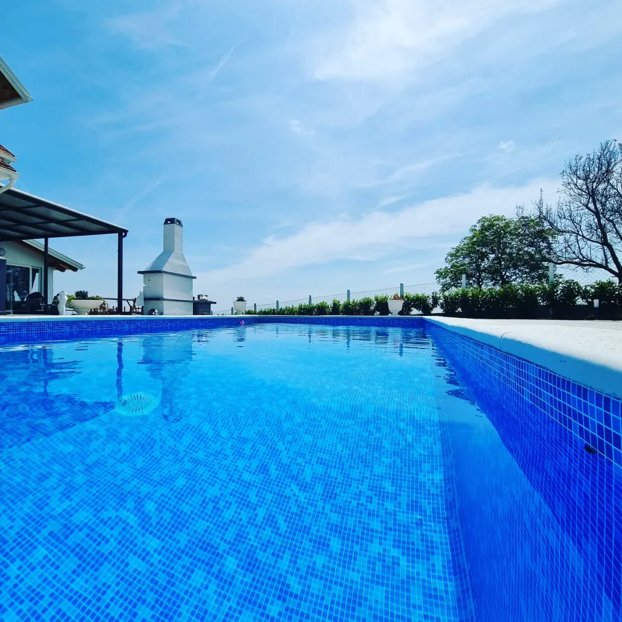 Veliki bazen vile za vjenčanja i roštilj u pozadini.