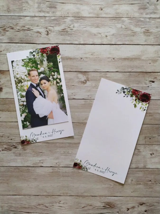 Fotografija mladenaca kao zahvalnica za vjenčanje na bijelom papiru ukrašenih rubova crvenim cvijećem.