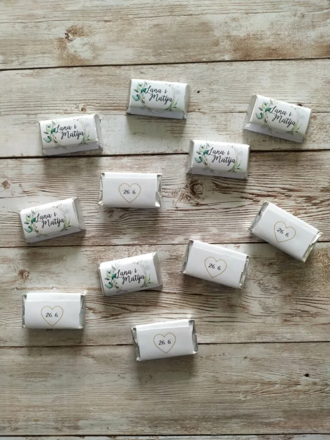 Čokoladice zahvalnice za vjenčanje ukrašene zelenim vijencem od lišća s imenima mladenaca u sredini, a na poleđini datum vjenčanja u srcu.